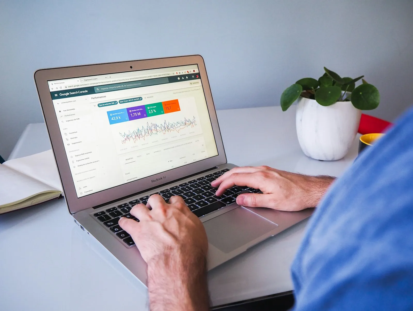Tableau de bord Google Search Console affiché sur un MacBook, mains sur le clavier